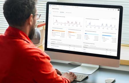 Mężczyzna przy komputerze, na którym wyświetla się usługa Zyxel SecuReporter