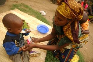 Matka karmi swoje dziecko pastą Plumpy Nut dla niedożywionych dzieci - fot. UNICEF/J.Pudlowski